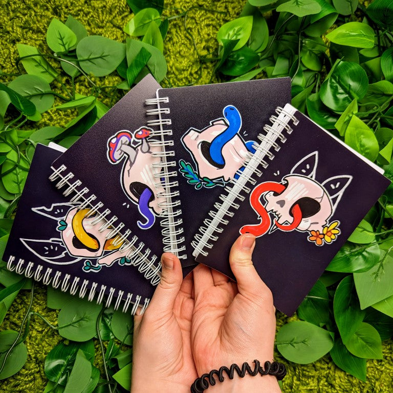 4 skull and snake sticker books in Milky's hands