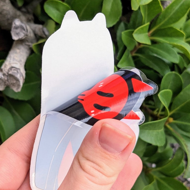 A demonstration of what the devil ghost window sticker looks like when the adhesive protectant sheet is peeled away.