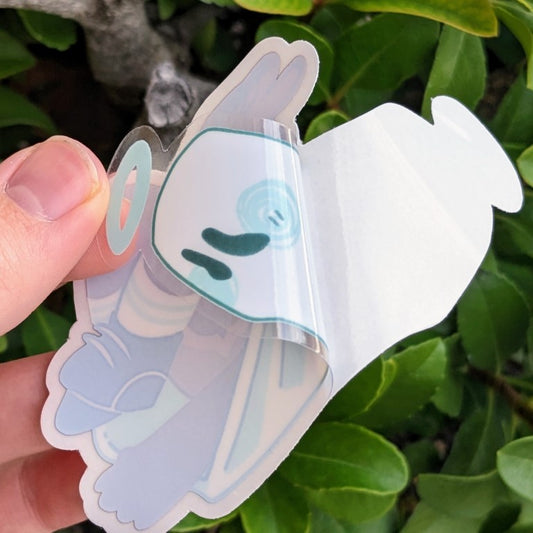 A demonstration of what the ghost angel window sticker looks like when the adhesive protectant sheet is peeled away.