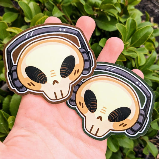 Two Aesthetic Skeleton Head Stickers, one with brown accents and one with green accents.