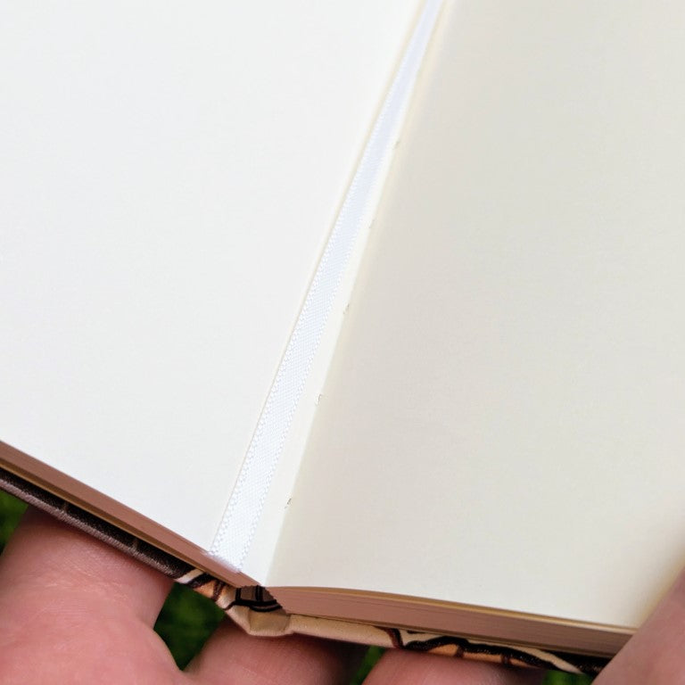 A closeup of the binding and bookmark of the aesthetic skeleton sketchbook