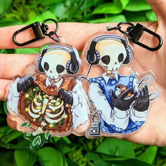 A pair of a brown and a blue chilling aesthetic skeleton cade keychains.