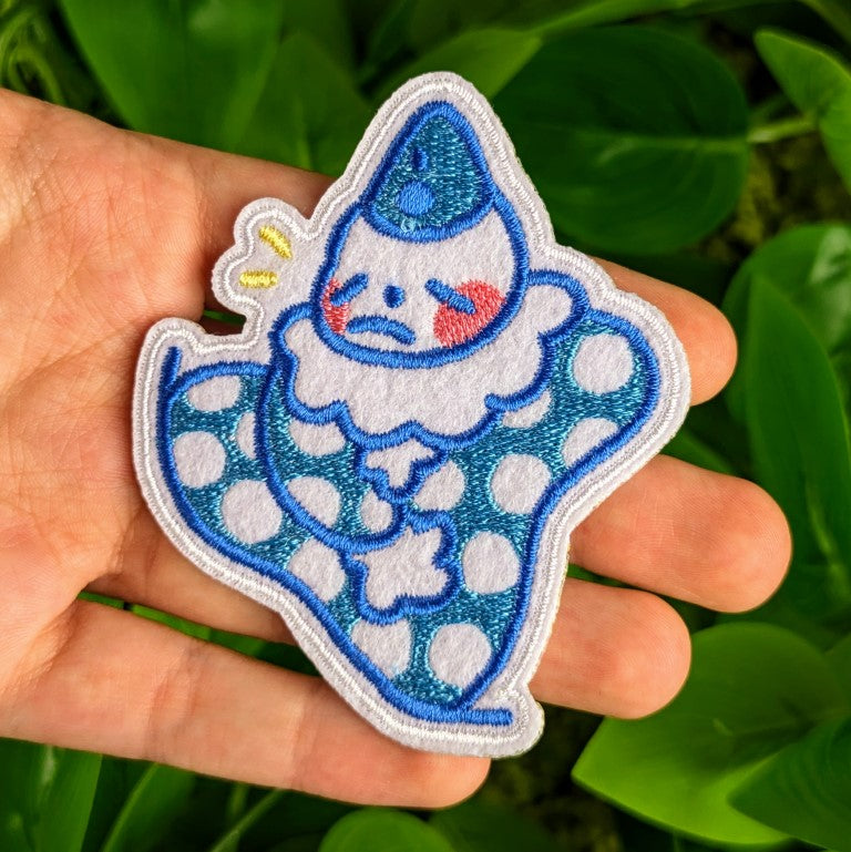 Blue Clown patch in Milky's hand