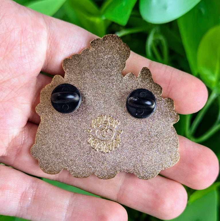 The back of Star Baby Clown Car enamel pin in Milky's hand