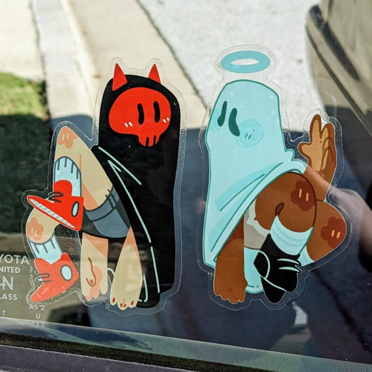Both the angel and devil ghost stickers on a car window.